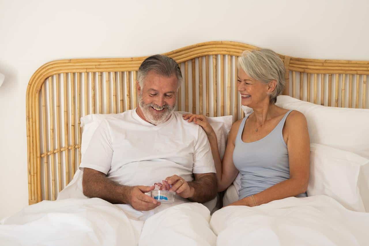 husband and wife smiling at sleep apnea device